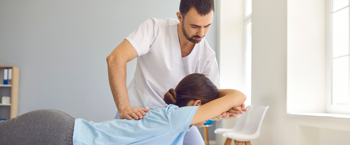 Therapist providing hands-on manual therapy to a patient in a bright, modern clinic offering combined chiropractic and massage care