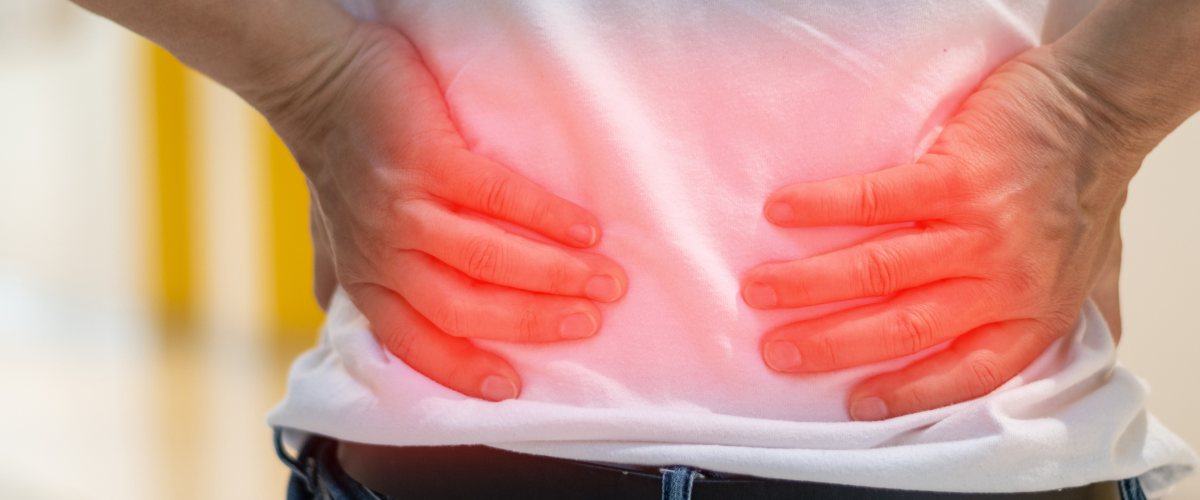 Patient holding their lower back due to pain from a bulging or herniated disc in Pottsville, PA