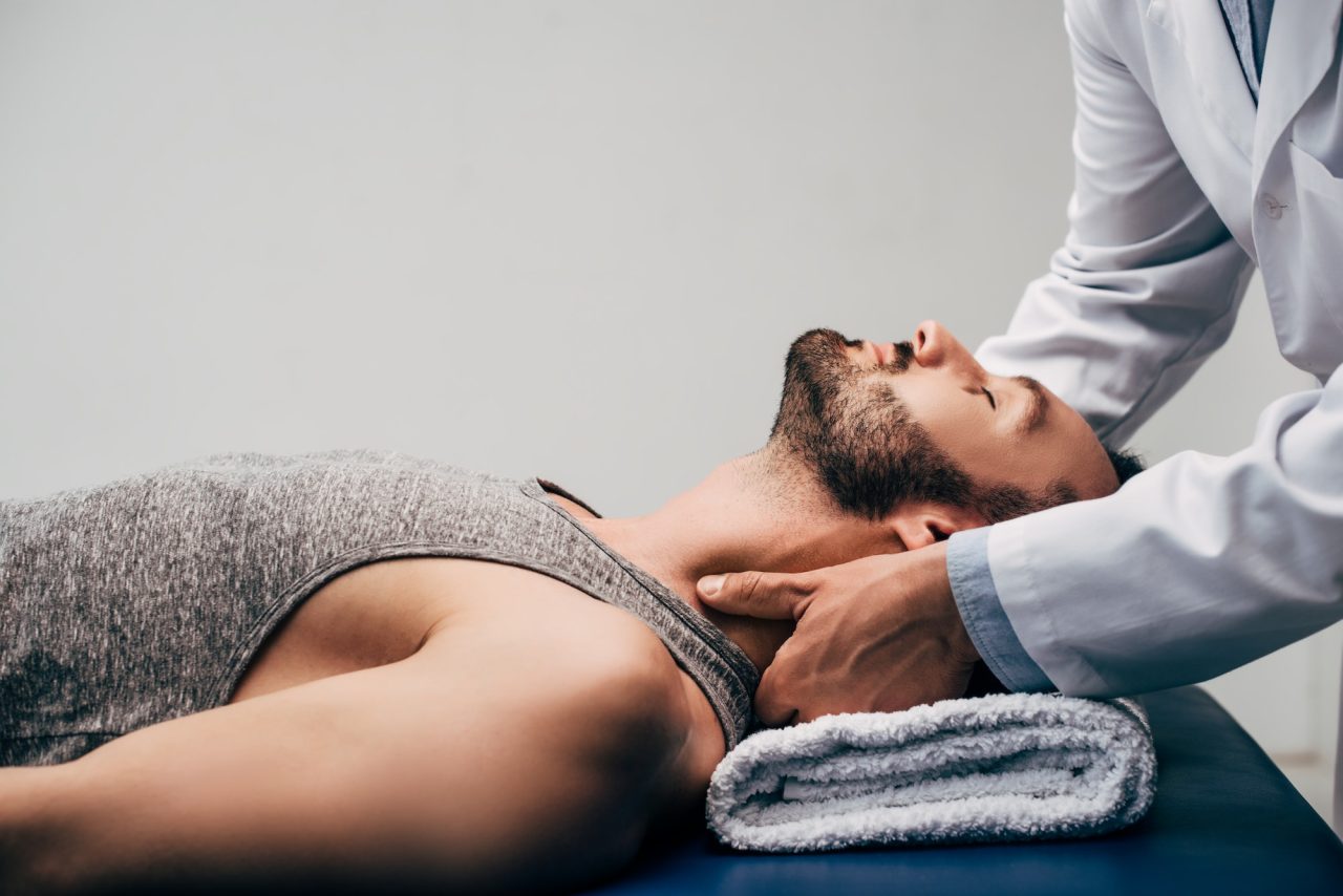 chiropractor massaging patient's neck