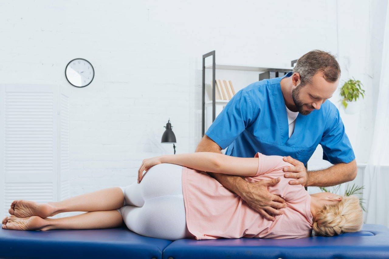 chiropractor massaging back of patient